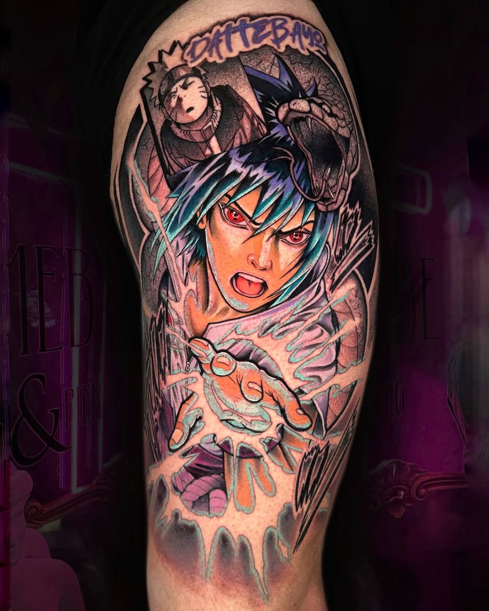 Colorful shoulder tattoo featuring an anime character with blue hair and red eyes, with smaller characters above, rendered in vibrant orange, purple, and teal tones.