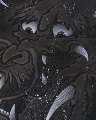 Dark ornamental lion face with pale blue eyes and silver sparkles scattered across black background, showcasing detailed linework and shading.