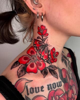 Red flowers with black butterfly and leaves on neck and shoulder, with "love now" text visible below.
