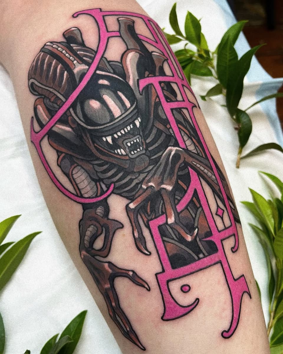 A biomechanical alien creature with exposed machinery and sharp teeth contained within a bright pink geometric border frame, tattooed on the calf.