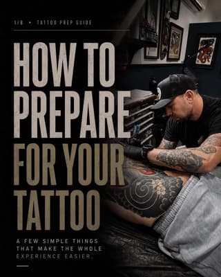 Tattoo artist working on a client's leg featuring a detailed floral and spiral design in black ink during a studio session.