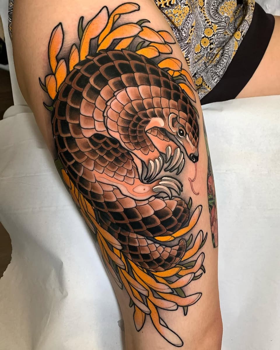 Dragon head with scaled body and orange flame-like foliage adorning the thigh and leg area in orange, black, and tan colors.