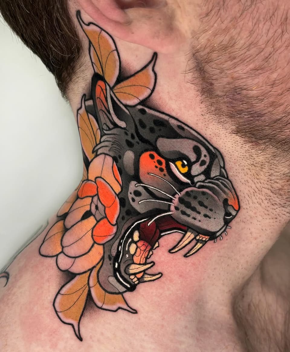 Colorful neck tattoo featuring a dark rat with red eyes and yellow fangs beside an orange flower with petals.