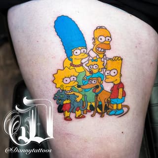 Colorful tattoo on thigh featuring the Simpson family characters in yellow, blue, and red with their pet dog and cat grouped together.