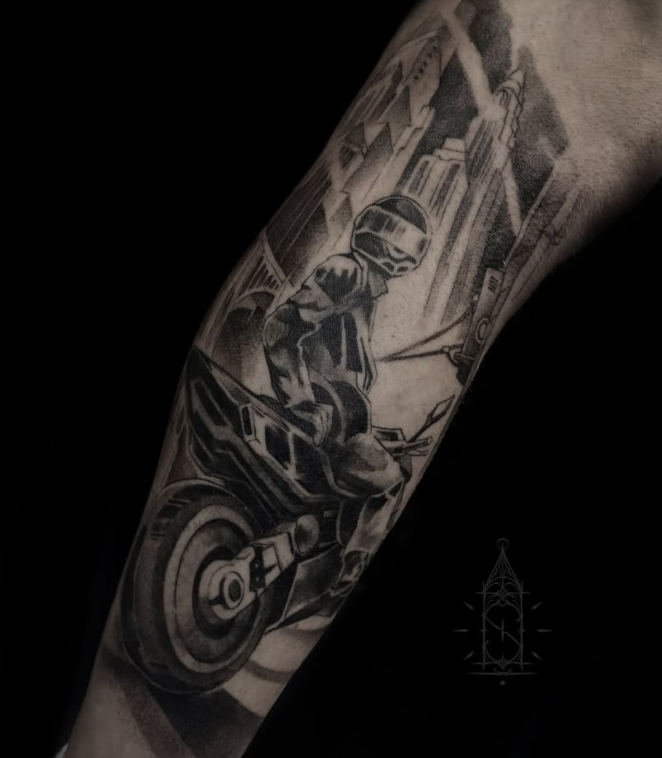 Monochrome arm tattoo featuring a seated figure in futuristic armor and helmet with mechanical details, urban cityscape background, and circular design elements.