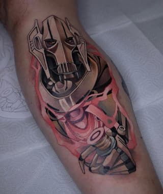 Colorful tattoo on an arm featuring a mechanical skull mask with glowing eyes and red watercolor elements blending into anatomical structures below.