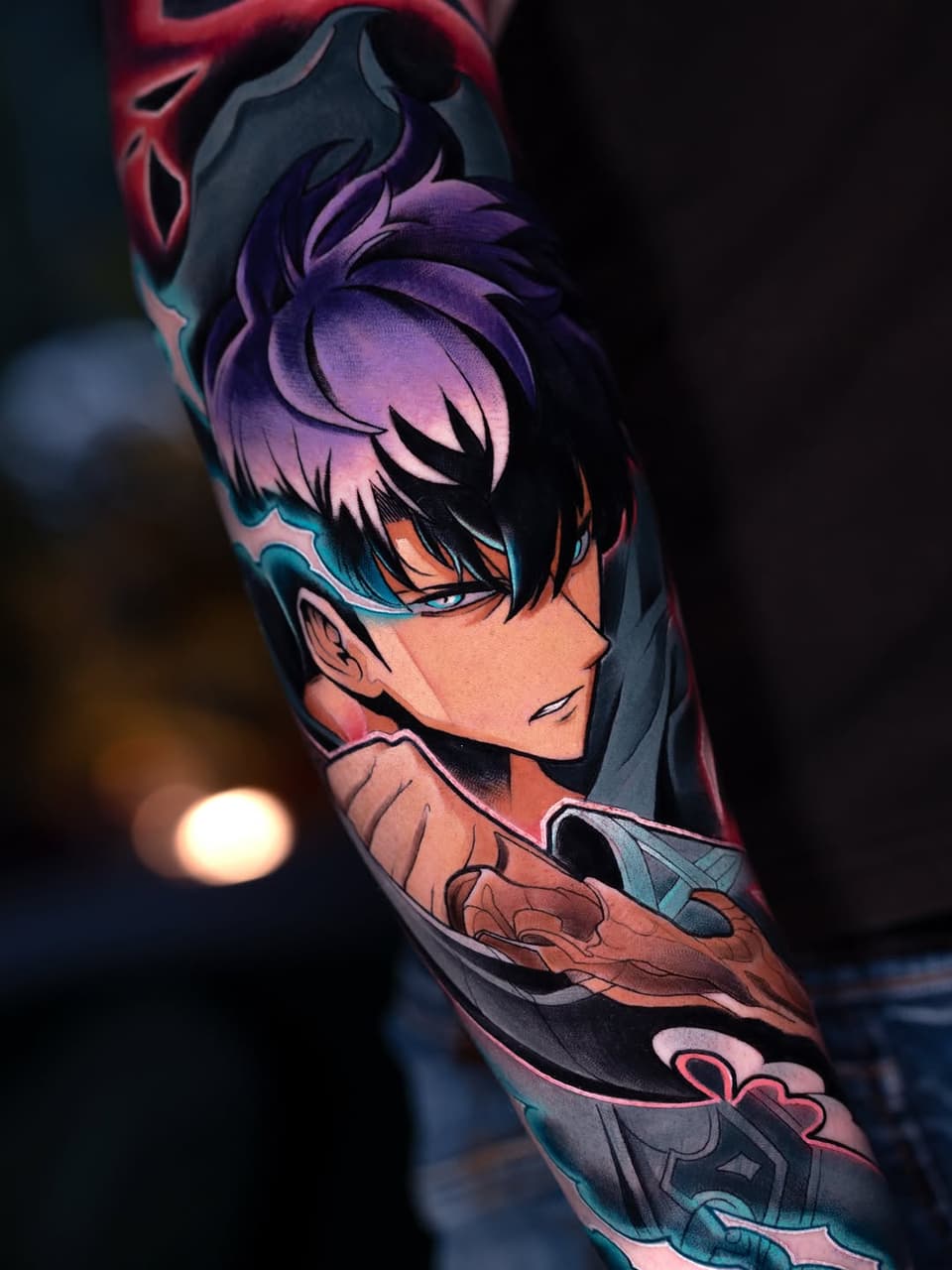 Colorful anime character portrait tattoo on arm featuring purple hair, teal eye mask, peach skin tones, and red accents with decorative elements below the neck.