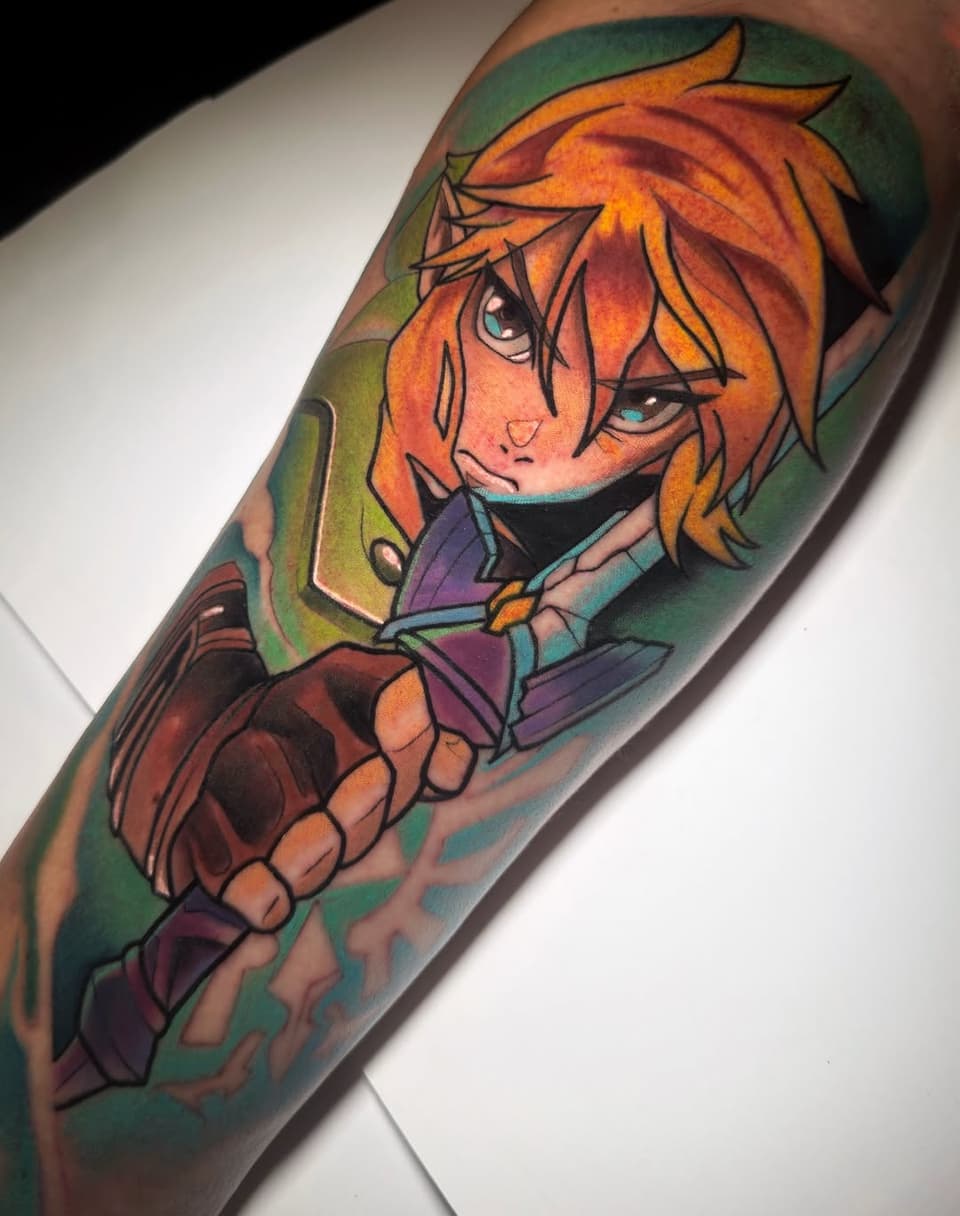 Colorful tattoo on forearm featuring an orange-haired anime character with blue eyes wearing purple clothing against a green background.