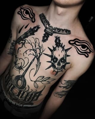Chest and arm tattoos featuring a spiked skull, birds with outstretched wings, bare tree branches, and decorative line work in black ink.