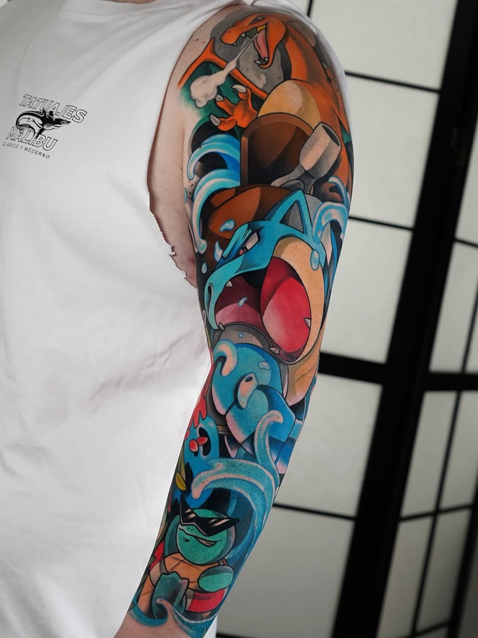 Colorful full-length arm sleeve tattoo featuring animated characters with vibrant orange, blue, red, and green hues on the wearer's shoulder to wrist.