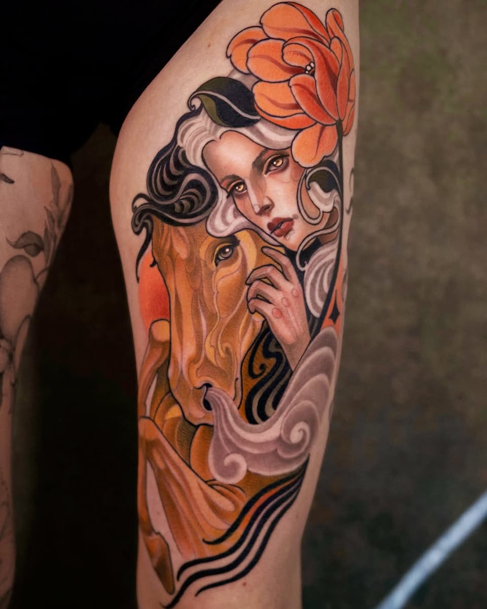 Colorful arm tattoo featuring a woman's face with flowing hair, orange flower above her head, and warm orange and black decorative elements below.