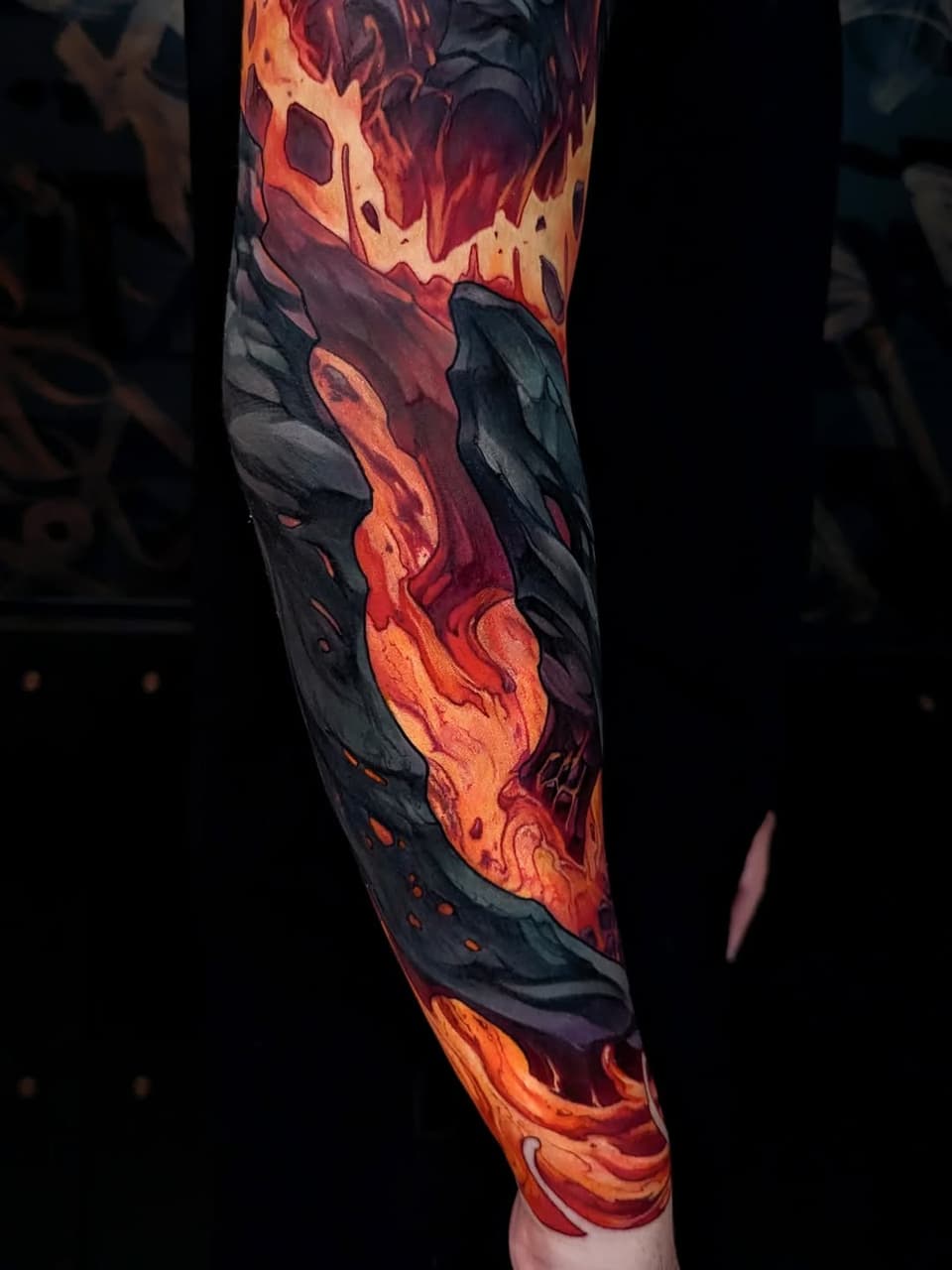 Full-length arm sleeve tattoo featuring flowing lava and molten rock in orange, red, and yellow against dark charcoal backgrounds.