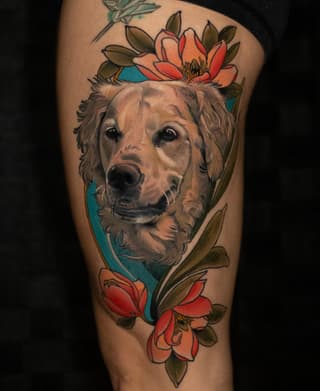 Dog's head portrait surrounded by red and orange flowers with green leaves on a blue background, tattooed on thigh.