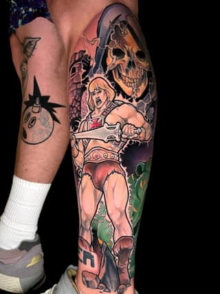 Colorful leg sleeve tattoo featuring a muscular warrior with blonde hair holding an axe, skull imagery, and fantasy creatures in orange, green, and red tones.