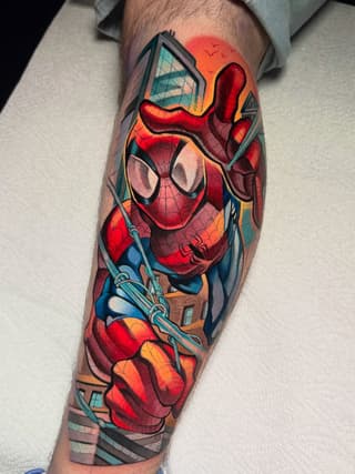 Spider-Man in dynamic pose with cityscape background tattooed on the forearm in vibrant reds, blues, oranges, and yellows.