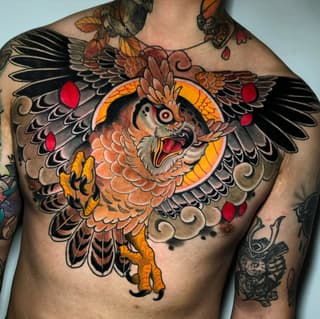 Colorful owl chest tattoo featuring orange and black wings, red details, yellow talons, and a glowing circular background on a shirtless male torso.