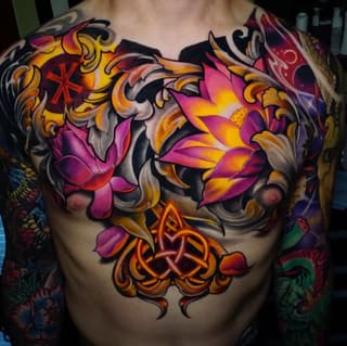 Colorful chest tattoo featuring pink and orange flowers with ornamental scrollwork and Celtic knotwork in gold and red tones.