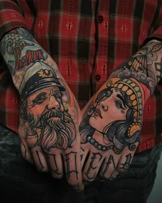 Two ornate portrait heads with jewelry and decorative elements tattooed on knuckles and hands in red, orange, black, and skin tones.