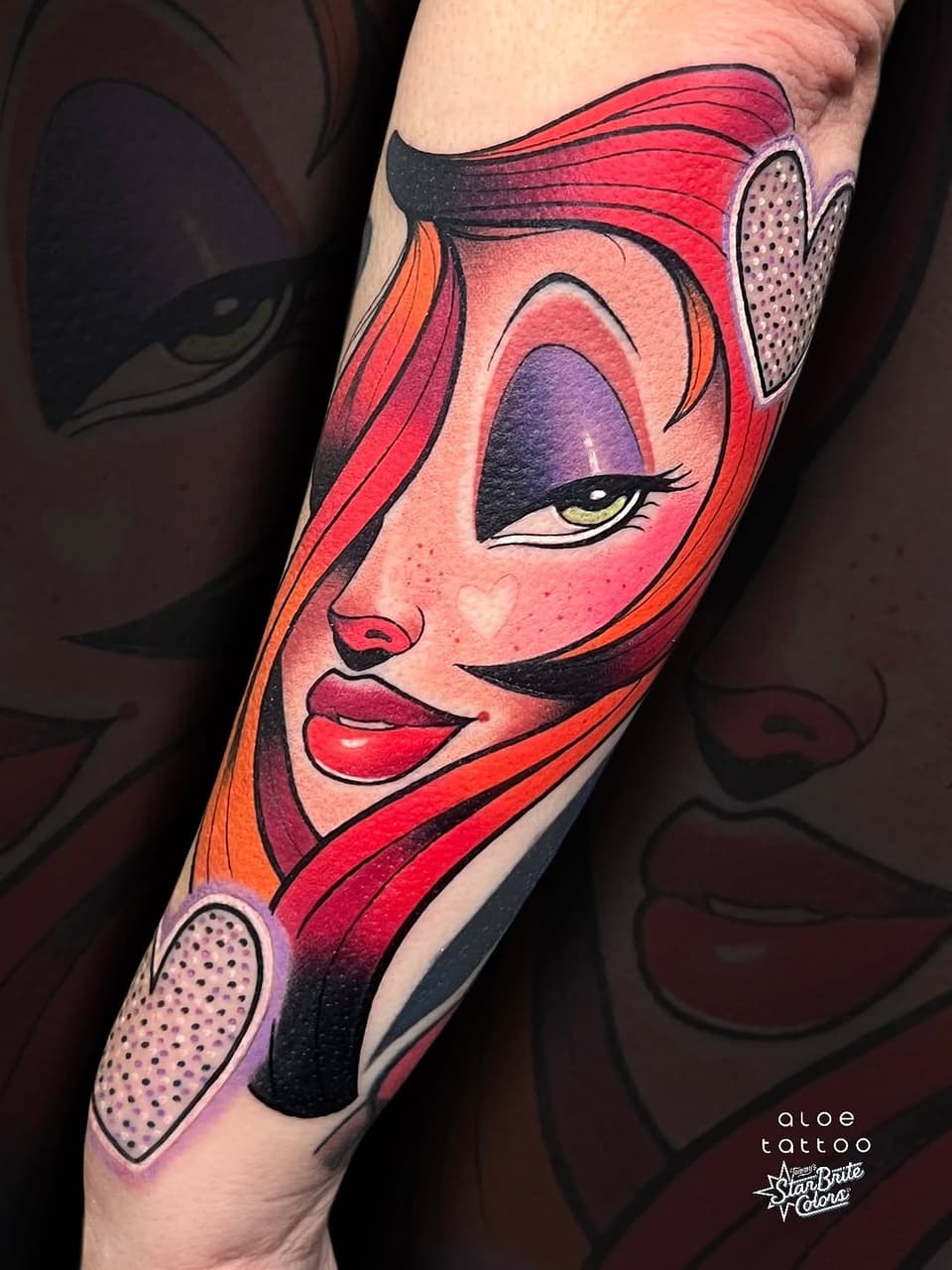 Colorful portrait tattoo of a woman with red hair, bold graphic features, and decorative dotted elements on the forearm.