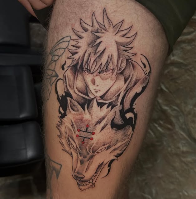 Jujutsu Kaisen character Yuji Itadori tattoo on thigh featuring spiky hair, facial expression, and demon face design with red accents.
