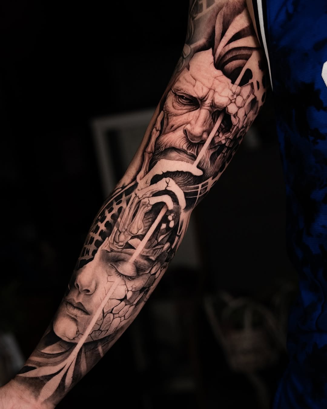 Monochrome portrait sleeve featuring three male faces with detailed shading and textured backgrounds on the forearm.