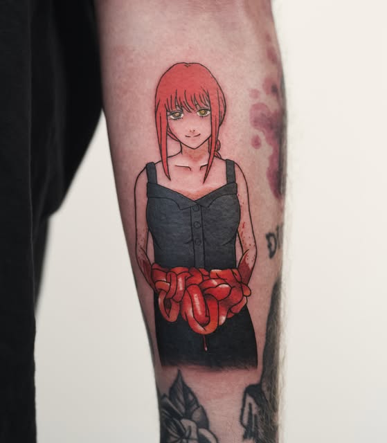 Anime girl with red hair and black dress holding red intestines tattooed on shin, with other tattoos visible nearby.
